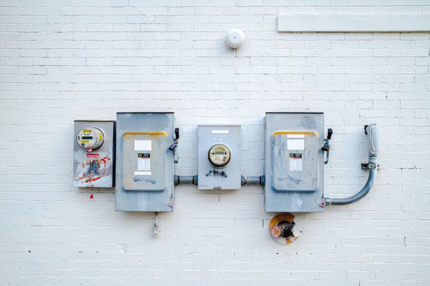 Industrial energy meter panel on a factory floor with production equipment in the background