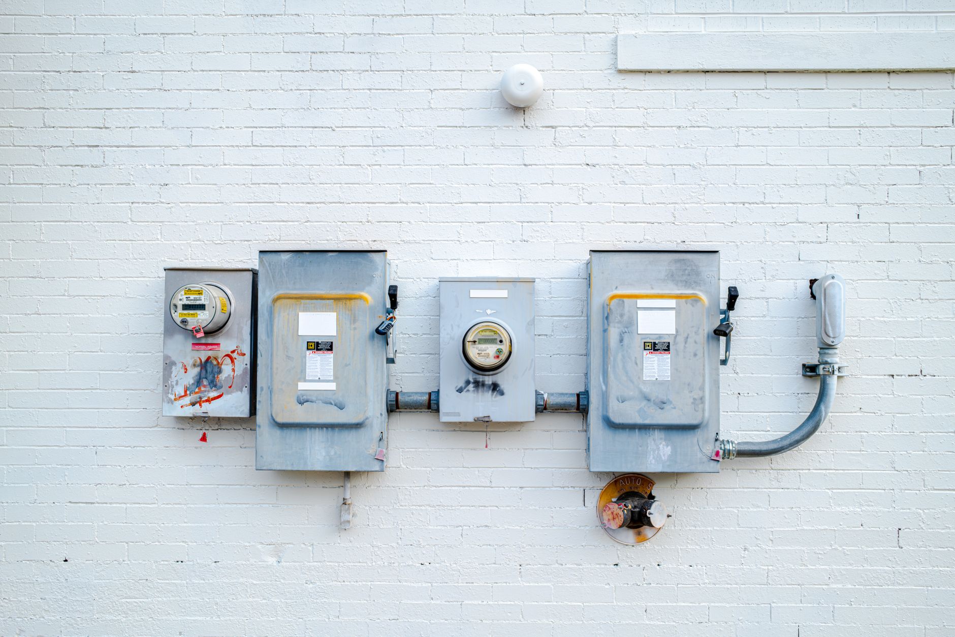 Industrial energy meter panel on a factory floor with production equipment in the background