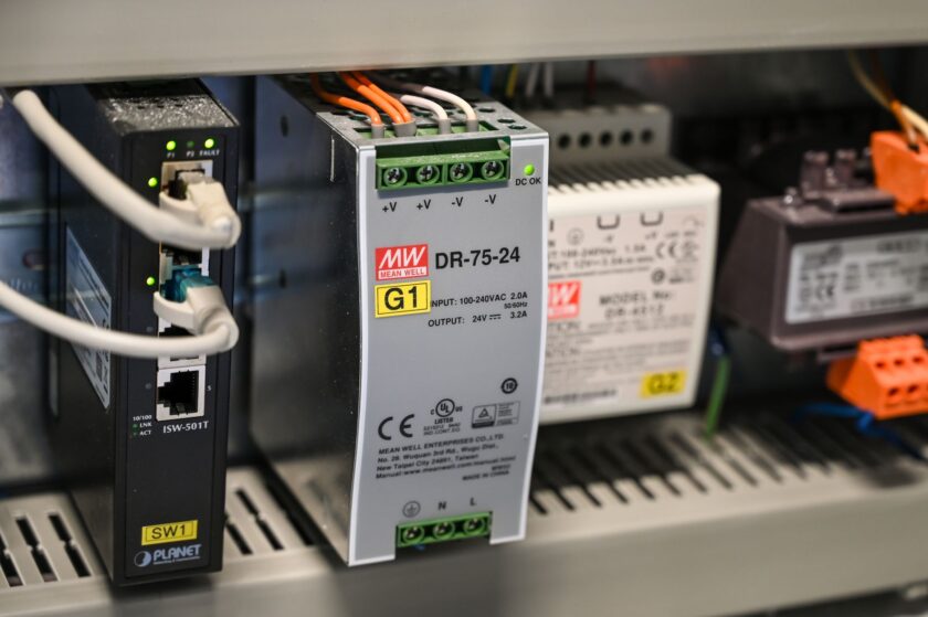 Technician reviewing network cabling and control panel in an industrial facility