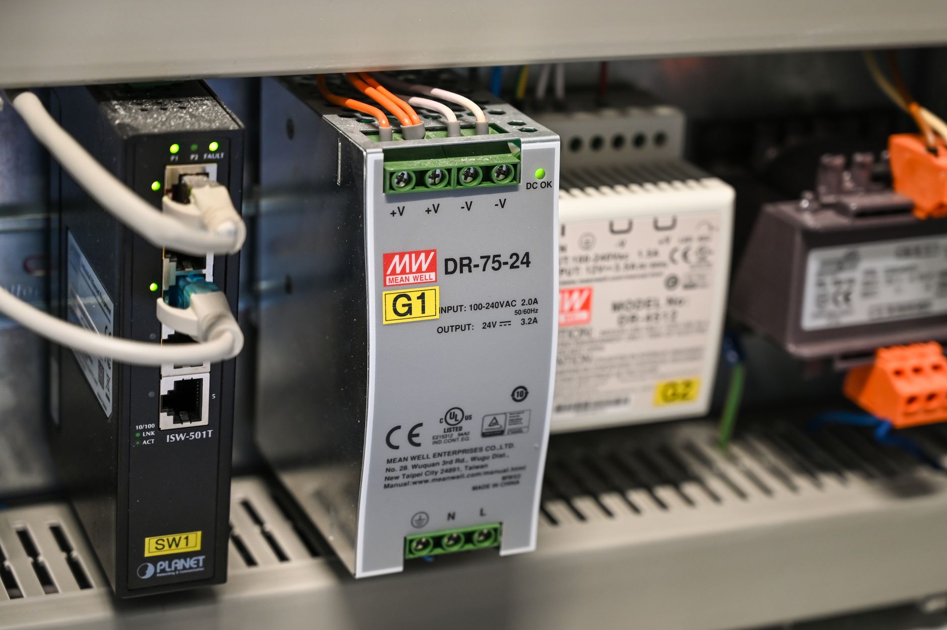 Technician reviewing network cabling and control panel in an industrial facility