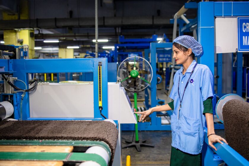 Factory operator using a tablet-based app on the production line, representing a low-code MES interface