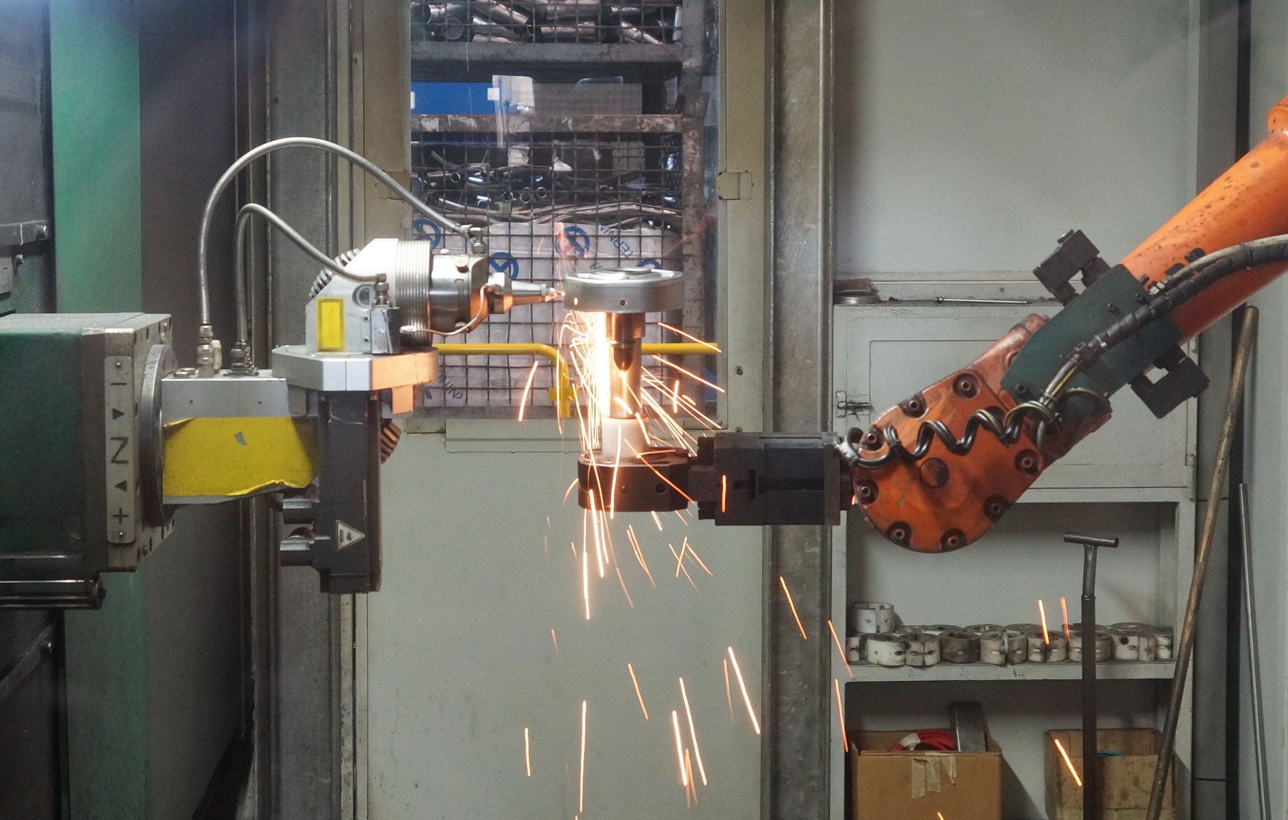 Collaborative robot arm working near a fixed industrial robot inside a shared manufacturing cell