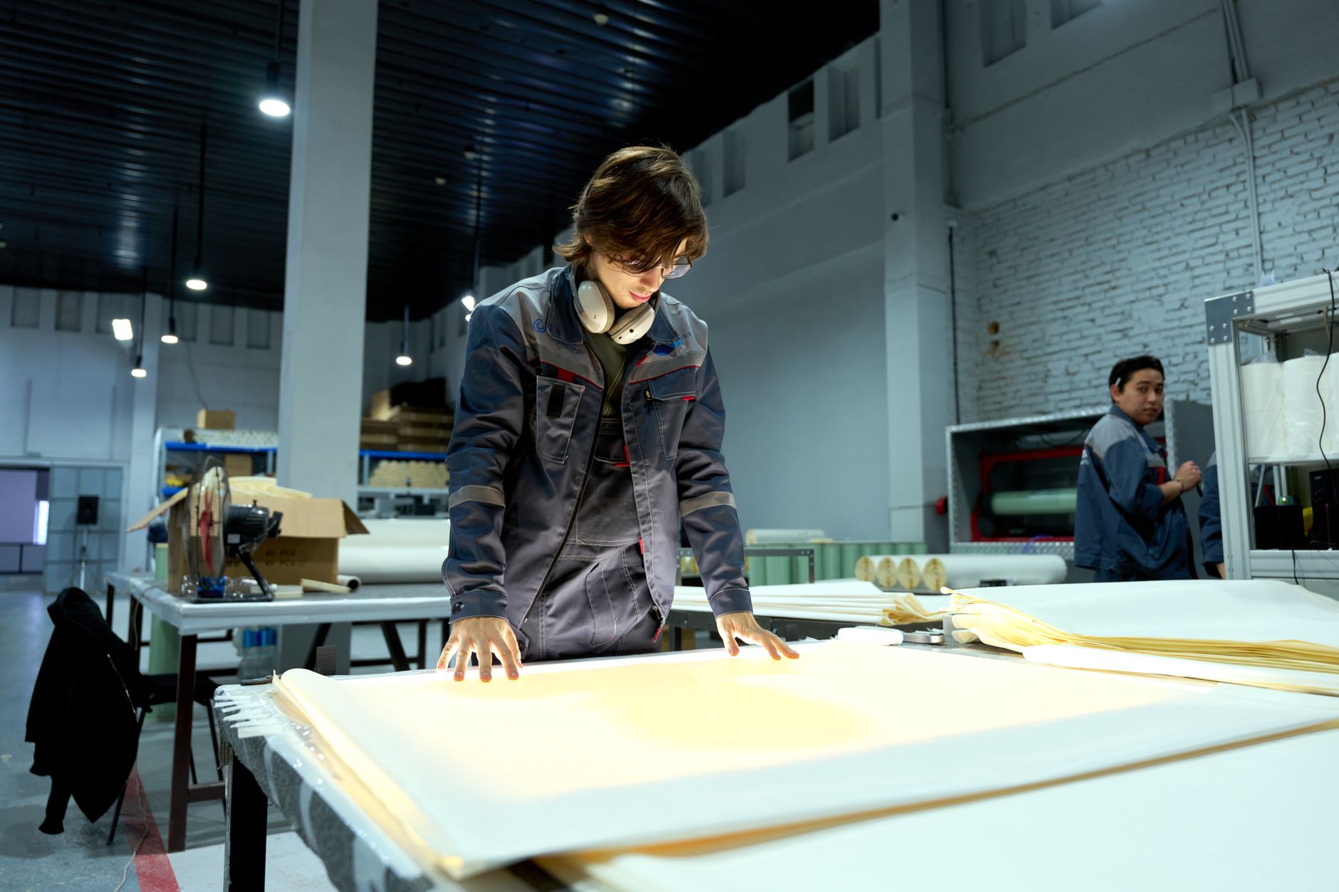 Quality engineer reviewing defect data on a shop-floor terminal next to a production line
