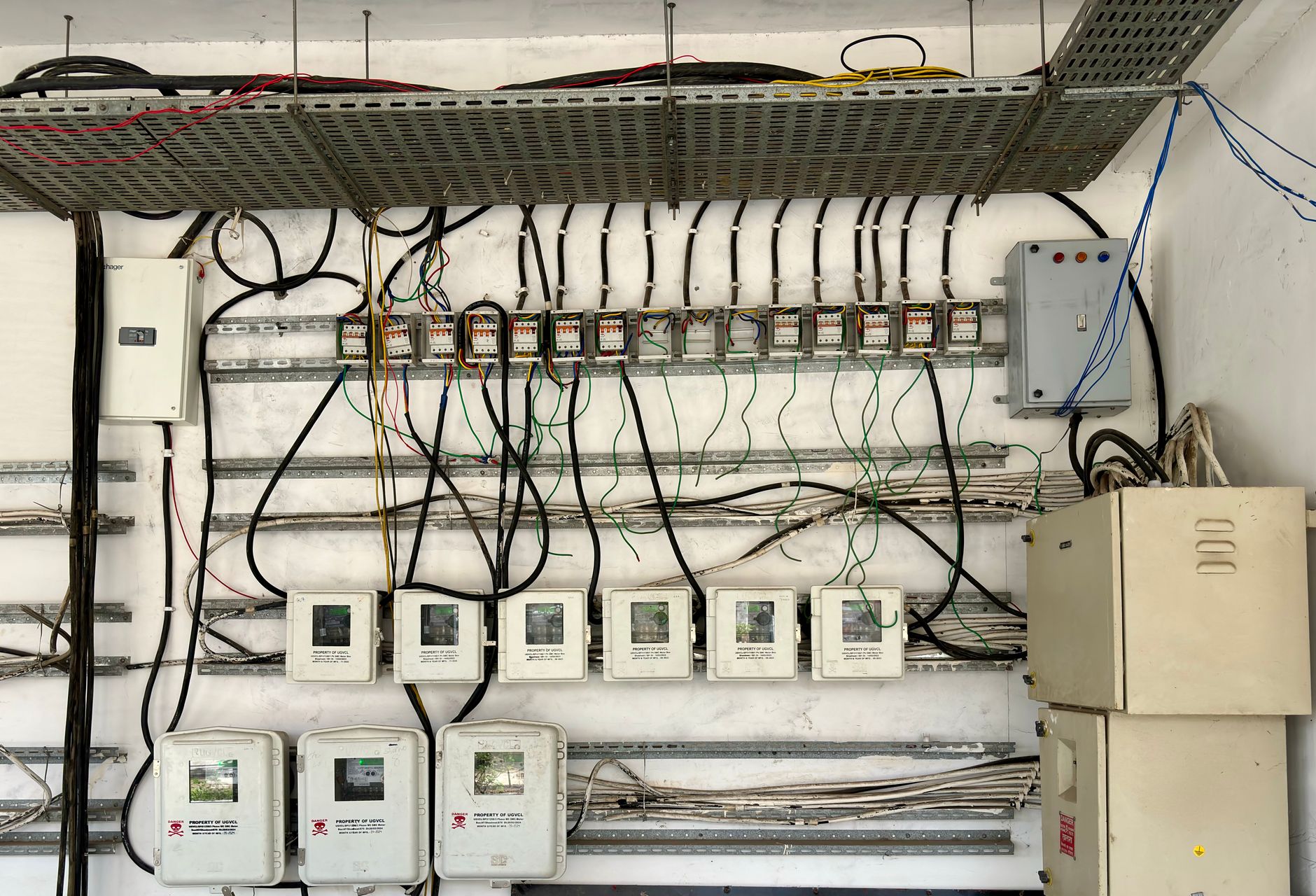 Engineer reviewing a contract next to an industrial control panel and SCADA screens