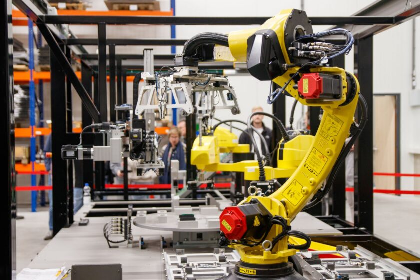 Industrial robot arm performing pick and place work in a manufacturing cell